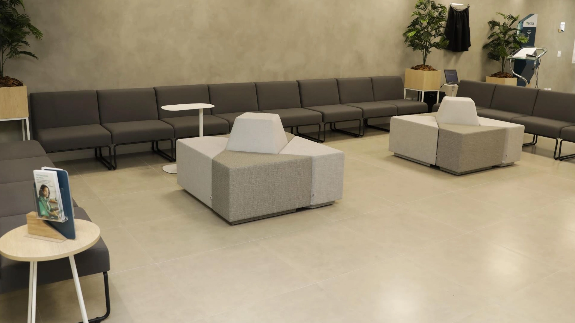 Bancos modulares em linha e poufs de apoio em área de espera corporativa