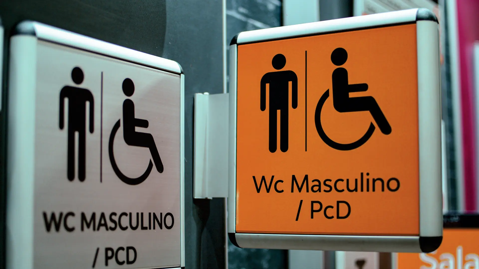 Placas bandeira pictográficas indicando WC Masculino e acesso PCD